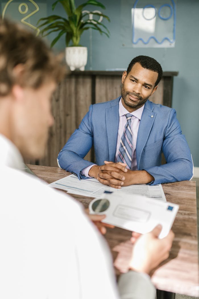 Two businessmen engage in a discussion at a professional office setting.